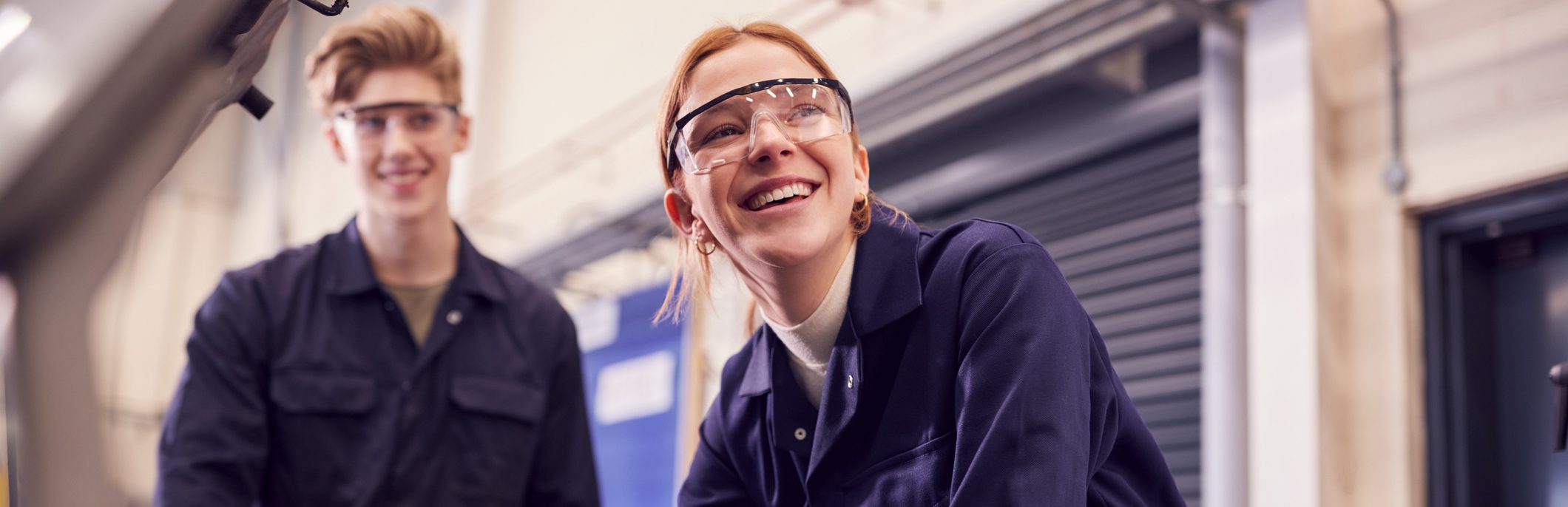 Männliche und weibliche Studenten, die auf Automotor auf AutoMechaniker-Lehrgang an der Hochschule schauen – Stockfoto